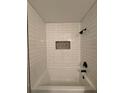 White subway tile shower with a unique stone accent at 2002 Country Park Se Dr, Smyrna, GA 30080