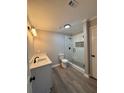 Modern bathroom with walk-in shower, gray walls, and vinyl plank flooring at 2002 Country Park Se Dr, Smyrna, GA 30080