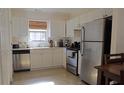 White kitchen with stainless steel appliances and wood cabinets at 2920 Fleetwood Dr, Cumming, GA 30041