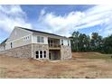 View of home's exterior featuring stone accents, siding, and a deck, all under a blue sky at 14 Cambridge Ln, Dallas, GA 30157