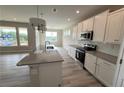Bright kitchen featuring a large island, white cabinetry, and stainless steel appliances at 14 Cambridge Ln, Dallas, GA 30157