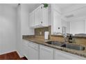 Well-lit kitchen featuring granite countertops, stainless steel sink, and white cabinets at 2700 Pine Tree Ne Rd # 2306, Atlanta, GA 30324
