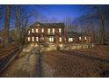 Brick home with stone patio and landscaping at dusk at 1422 Hillside Dr, Grayson, GA 30017