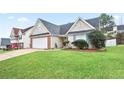 Tan brick house with white garage door and neatly landscaped yard at 559 Ransom Way, Stockbridge, GA 30281