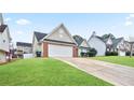 Tan brick house with white garage door and a lush green lawn at 559 Ransom Way, Stockbridge, GA 30281