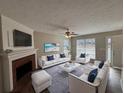 Bright living room featuring a fireplace, ceiling fan, and modern furnishings at 7645 Broadhurst Dr, Riverdale, GA 30296