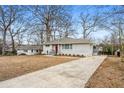 Beautiful house featuring a gray brick exterior, a well-manicured front yard, and a paved driveway at 3215 Concord Cir, Smyrna, GA 30080