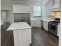 Bright kitchen featuring a spacious island, stainless steel appliances and white cabinetry at 3215 Concord Cir, Smyrna, GA 30080