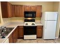 Galley kitchen with wood cabinets, and white appliances at 2087 Grove Way, Hampton, GA 30228