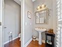 Small powder room with pedestal sink and hardwood floors at 110 Pro Ter, Johns Creek, GA 30097