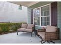 Relaxing front porch with wicker furniture and view of manicured hedges at 555 Winder Trl, Canton, GA 30114