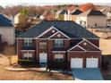 Brick two-story house with a two-car garage and landscaped yard at 3971 Busby Mill Ct, Ellenwood, GA 30294