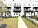 Modern white brick townhouse with balcony, walkway, and lawn at 1031 Robert Smalls Way, Atlanta, GA 30318