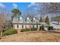 Brick ranch house with dormer windows, attached garage, and landscaped yard at 5352 Waterford Dr, Dunwoody, GA 30338