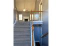 View of a staircase with a wooden railing and carpeted steps at 608 Morgans Trce, Ellenwood, GA 30294