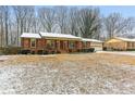 Ranch style home with snow-covered lawn and mature trees at 763 Windy Sw Dr, Stone Mountain, GA 30087