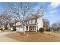 Charming two-story home featuring a well-manicured lawn and inviting front porch with stone accents at 702 Berkeley Ter, Canton, GA 30115