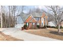 Brick home featuring a spacious driveway and attached garage at 305 Corrigan Trce, Peachtree City, GA 30269