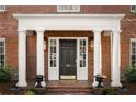 Elegant front entrance with columns, a black door, and brick facade at 769 Penn Ne Ave, Atlanta, GA 30308