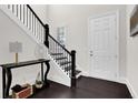 Elegant entryway with dark hardwood floors, a staircase with black railing, and a console table at 399 Tillman Pass, Woodstock, GA 30188