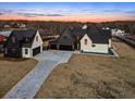 Aerial view of a modern farmhouse with attached garage and paved driveway at 5180 Howard Rd, Cumming, GA 30040