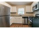 Bright kitchen with stainless steel appliances, granite countertops, and sleek white cabinets for a modern feel at 2405 County Line Sw Rd, Atlanta, GA 30331