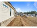 Home's exterior side view, brick base, and gently sloping backyard at 1682 Juniper Berry Way, Loganville, GA 30052