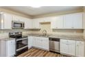 Renovated kitchen with white cabinets, granite countertops, and stainless steel appliances at 3164 Delmar Nw Ln, Atlanta, GA 30311