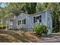 A quaint blue house with black shutters, a welcoming front porch, and lush greenery at 1626 Kenmore Sw St, Atlanta, GA 30311