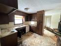 Dated kitchen with dark wood cabinets and vinyl flooring at 1783 Nicole Ln, Lithonia, GA 30058