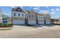 A row of brick and vinyl townhouses each with a two-car garage in a suburban community at 891 Eagle Ave, Riverdale, GA 30296