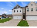 Stylish townhome with a two-car garage and professional landscaping creates a welcoming entrance at 891 Eagle Ave, Riverdale, GA 30274