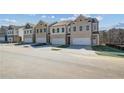 Row of new construction townhouses each with two car garages and neutral color brick at 891 Eagle Ave, Riverdale, GA 30296