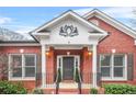 Brick front entry with columns, decorative accent, and dark gray door at 127 Ennisbrook Se Dr, Smyrna, GA 30082