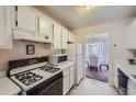 Kitchen features white cabinets, microwave, and stove at 1803 Ashborough Way # Apt F, Marietta, GA 30067