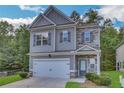 Two-story house with gray siding, stone accents, and a two-car garage at 204 Hickory Commons Way, Canton, GA 30115