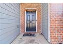 Dark-colored front door with brick and siding accents at 6397 Barker Station Walk, Sugar Hill, GA 30518