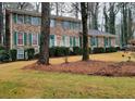 Two-story brick home with green shutters, landscaping, and a driveway at 714 Wetherborn Pl, Stone Mountain, GA 30083