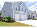 Two story house with light blue siding, three car garage, and landscaped yard at 121 Treeline Trl, Canton, GA 30115