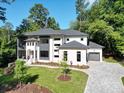 Luxury home with gray roof, white and gray exterior, and a large paved driveway at 4840 Northway Dr, Atlanta, GA 30342