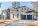 Modern home with white and gray exterior, two-car garage, and a stone driveway at 4840 Northway Dr, Atlanta, GA 30342