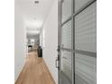Light and bright hallway with wood flooring and a grey door at 3576 Silvery Way, Powder Springs, GA 30127