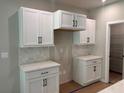 Kitchen area featuring white cabinets, contrasting dark hardware, and tile backsplash at 15 Cambridge Ln, Dallas, GA 30157