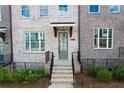 Townhouse front entrance with gray door and brick steps at 5215 Riden Ct, Buford, GA 30518