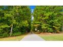 Scenic walking path lined with lush greenery and trees in a peaceful community setting at 13541 Whitman Ln, Covington, GA 30014