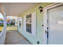 Side view of the front porch, showing white railings and light green siding at 6137 Raleigh Oaks Ct, Lithonia, GA 30058