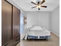 Neutral bedroom featuring a ceiling fan, floating shelves, closet and tile flooring at 148 Shady View Pl, Lawrenceville, GA 30044