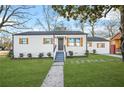 Recently renovated white house with gray roof, wooden shutters, and landscaped lawn at 1092 Donnelly Sw Ave, Atlanta, GA 30310