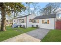 White house with gray roof and a spacious driveway, and wooden shutters at 1092 Donnelly Sw Ave, Atlanta, GA 30310