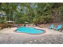 Inviting kidney-shaped pool surrounded by a patio and lush greenery at 2505 Ridgehurst Dr, Buford, GA 30518